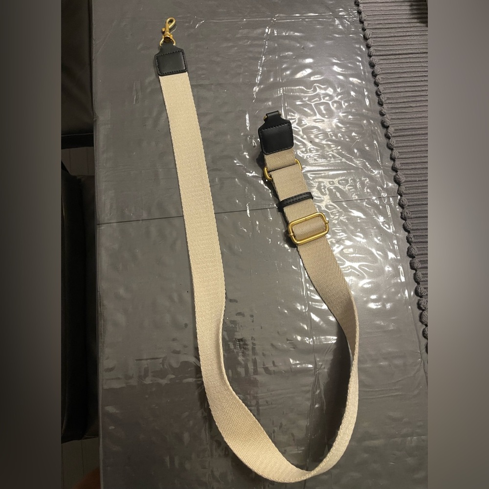 Stylish beige strap with black accents. Gold hardware. Adjustable length.